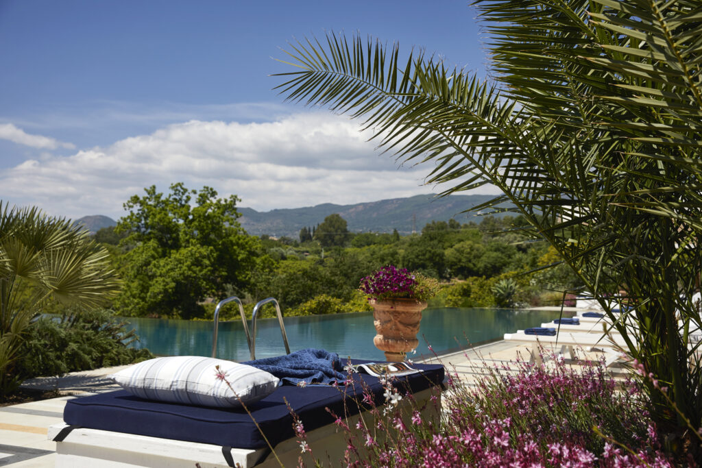 Another view of the villa private pool. It is surrounded by plants and nature with view of Mount Etna.